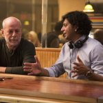 L-r: Bruce Willis returns as David Dunn. Writer/director M. Night Shyamalan on the set. Photo courtesy Universal Pictures.